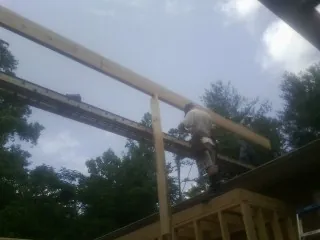 Carpenter setting a ridge beam over a new addition frame — Ice Dam Removal by Roofing Brothers in Lakemore