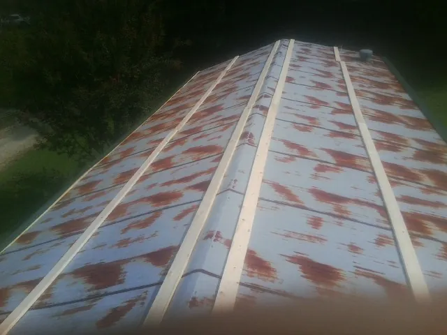 Rusted metal roof panels with new wood purlins before replacement — Storm Damage Roof Repair in Lakemore by Roofing Brothers